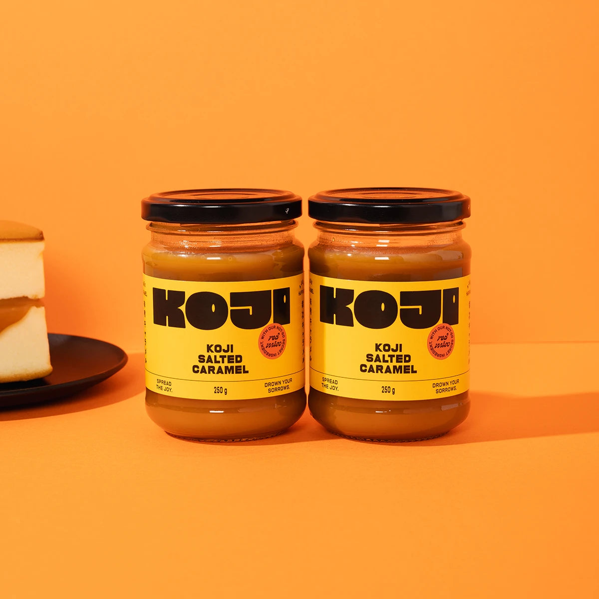 Two jars of Koji Salted Caramel on an orange background