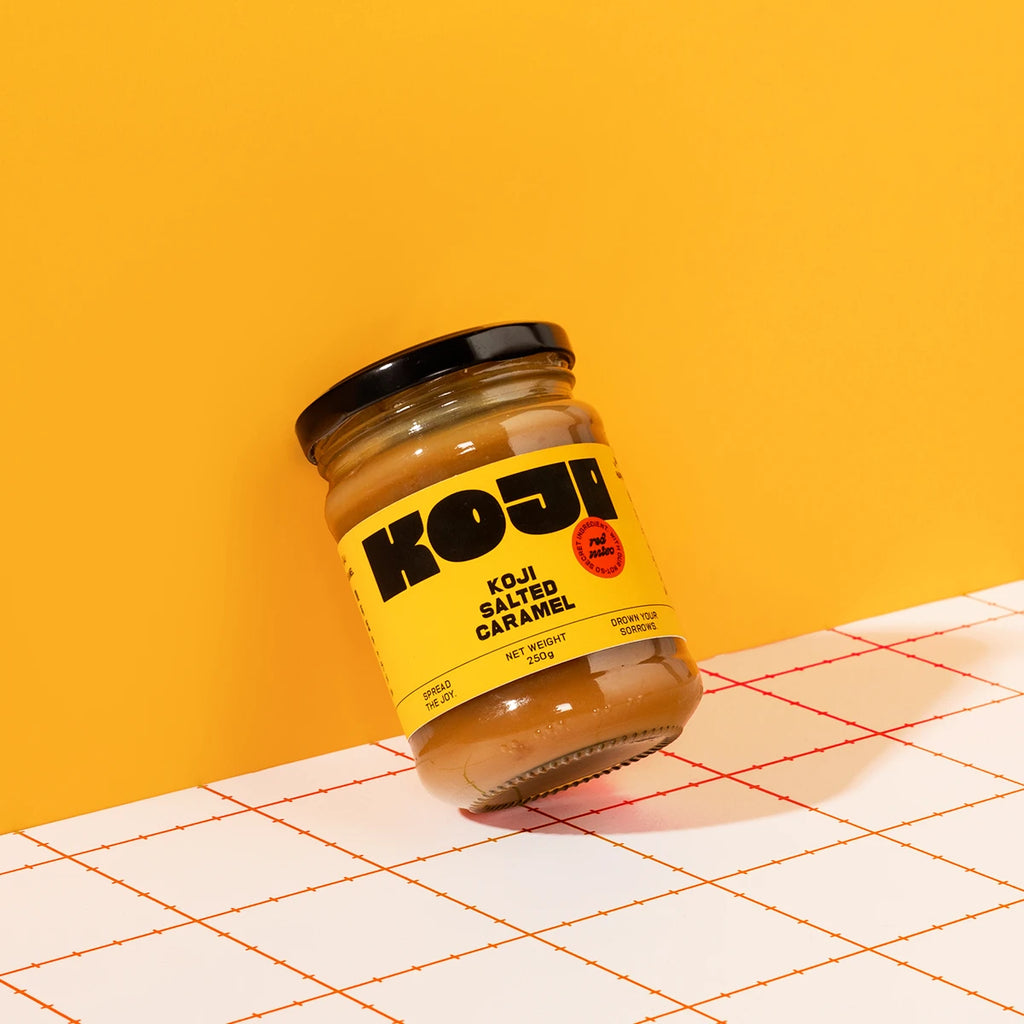 Jar of Koji salted caramel on a yellow background