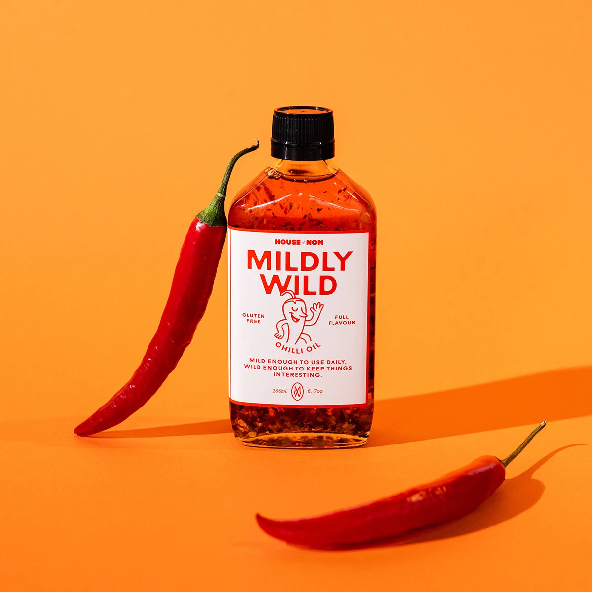 Bottle of 'Mildly Wild' chilli oil with a red chili pepper on an orange background
